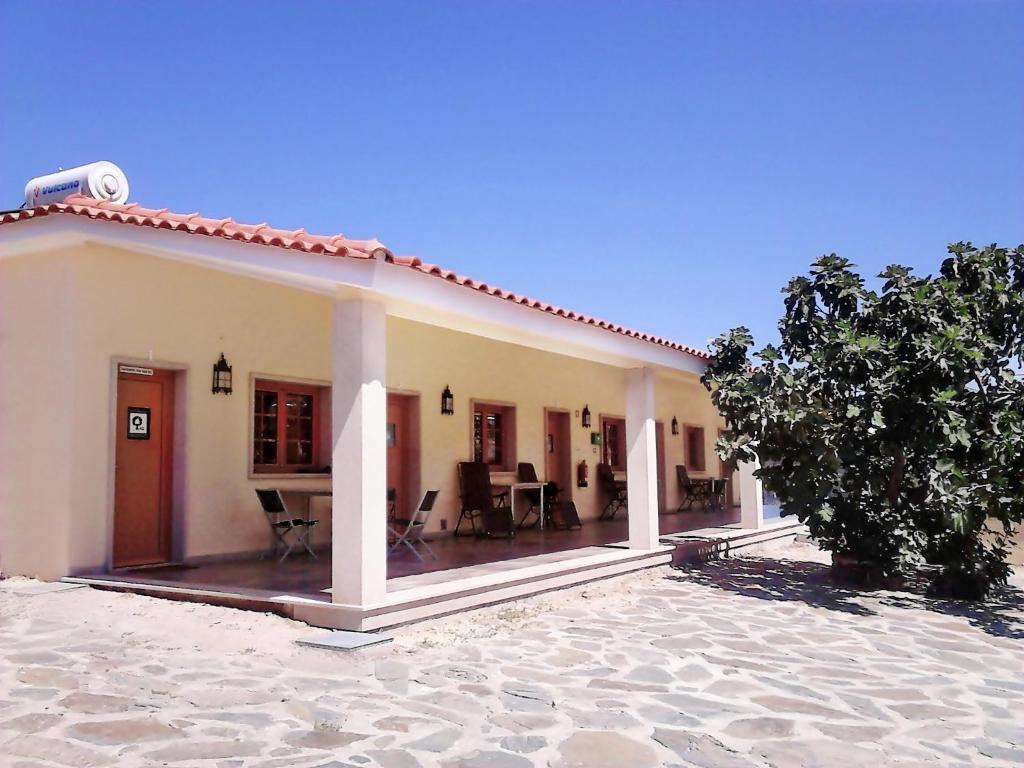 eine Villa mit einer Terrasse und einem Haus in der Unterkunft Quintas do Valbom e Cuco in Torre de Moncorvo