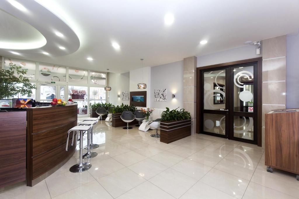 a large room with a hair salon with tables and chairs at Arkada Hotel in Bučovice