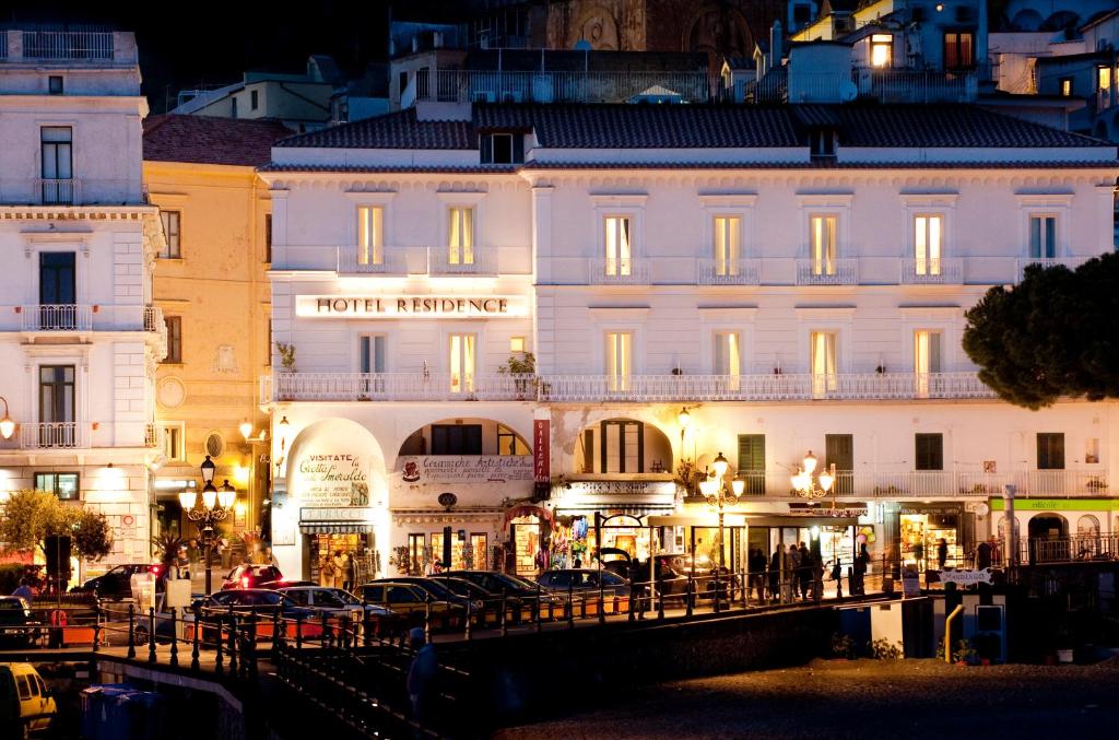 a large building with cars parked in front of it at Hotel Residence in Amalfi