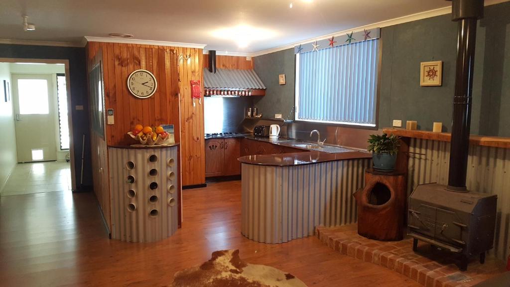 a kitchen with a counter and a clock on the wall at Inna Nutshell in Kingscote