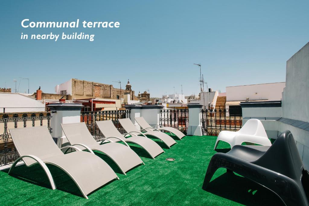 a row of white chairs on a roof at Hostly Acetres 1B-2B Center-Fibre-Conmunal terrace-Parking Optional in Seville