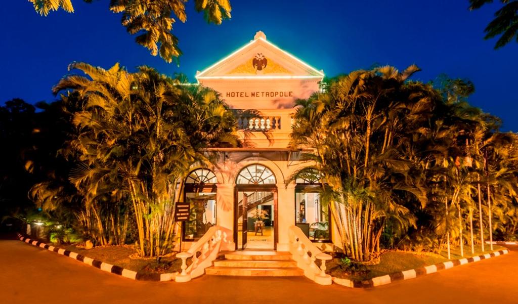 un edificio con palmeras delante en Royal Orchid Metropole Mysore, en Mysore