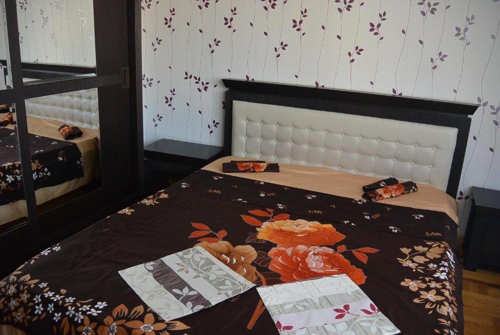 a bedroom with a bed with flowers on it at Star Apart in Râmnicu Vâlcea