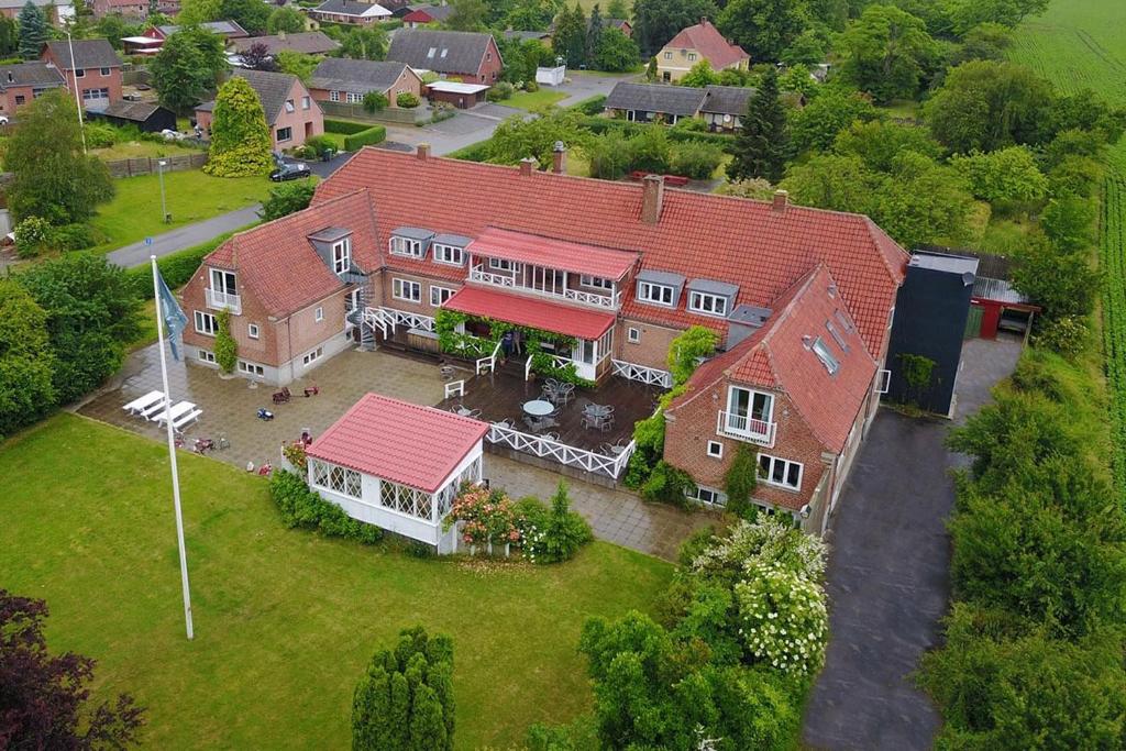 einen Blick über ein großes Haus mit rotem Dach in der Unterkunft Hotel Lolland in Nørreballe