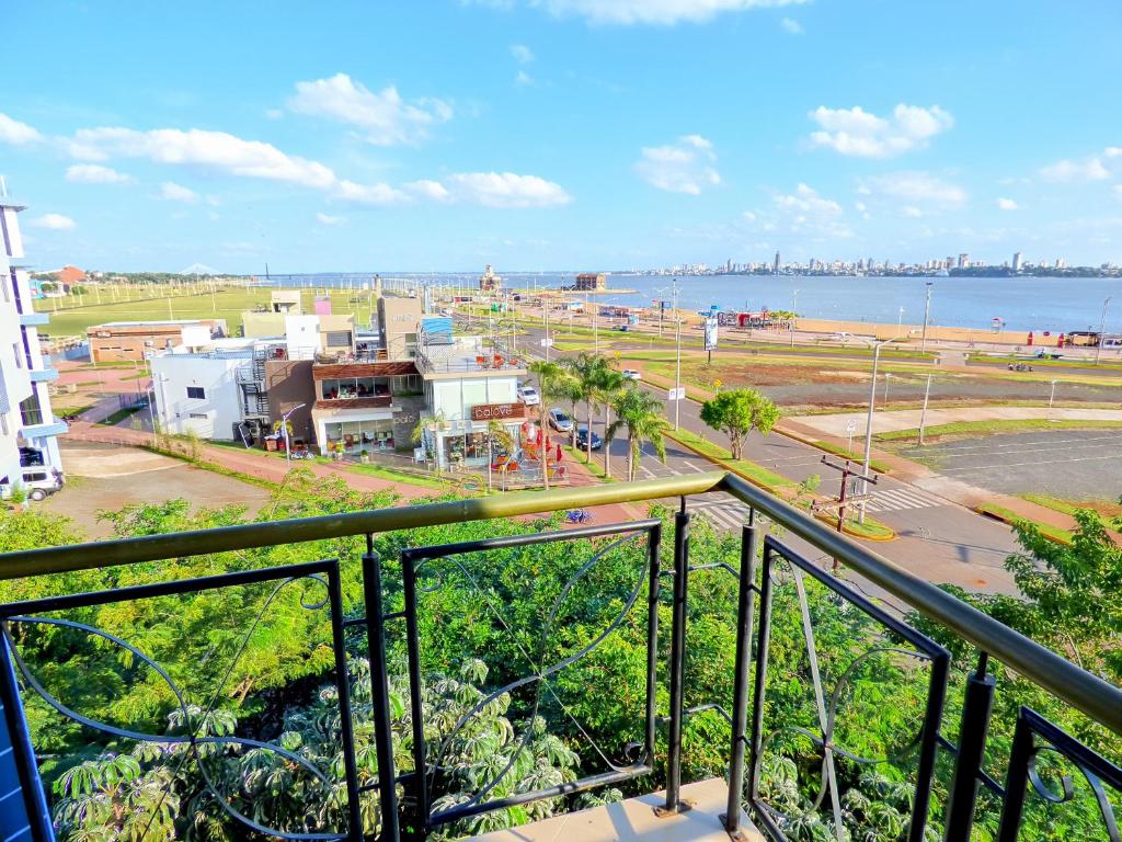 a balcony with a view of a city and the water at De La Costa Hotel in Encarnación