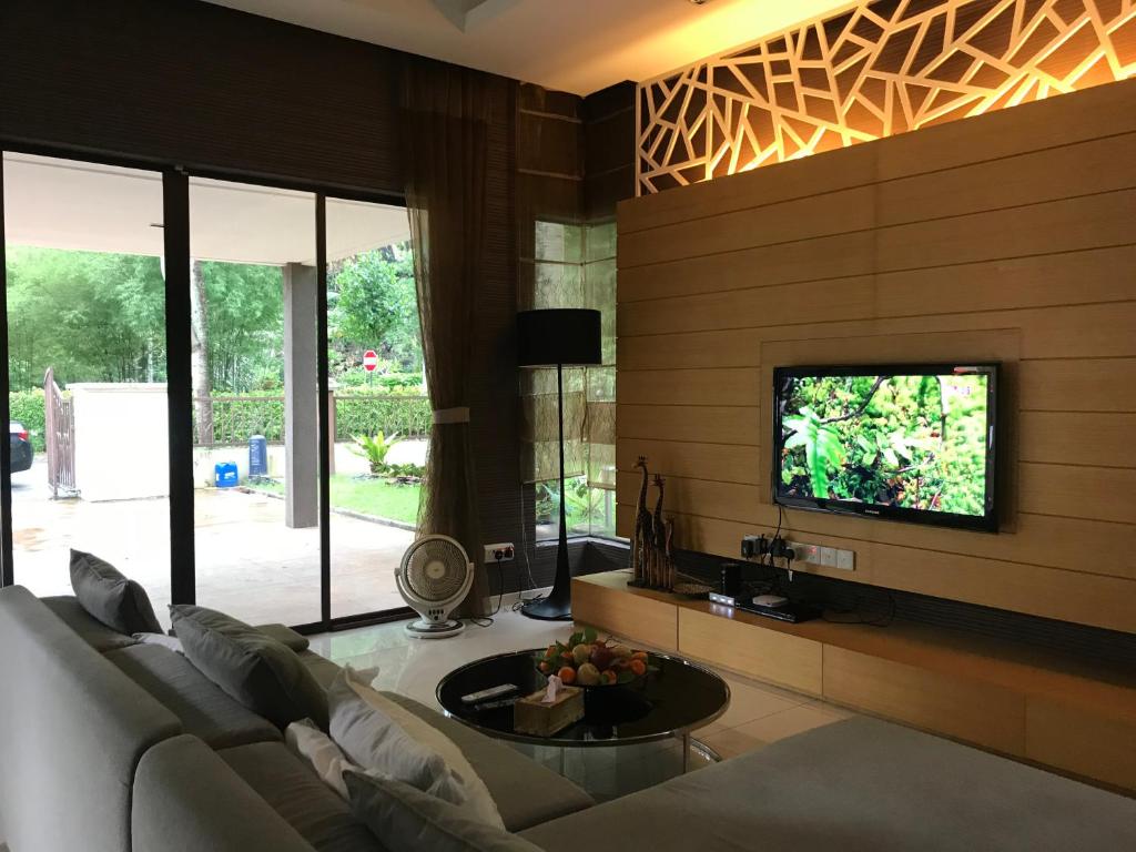 a living room with a couch and a tv at Lakeside Home in Ipoh