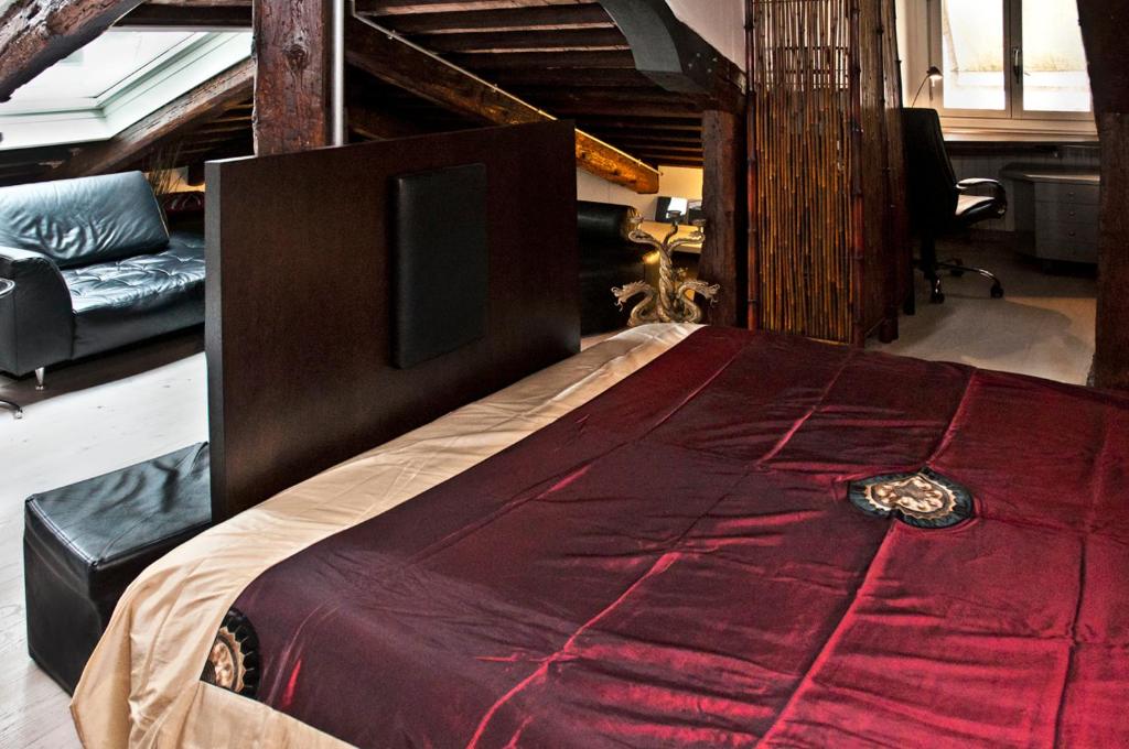 a bedroom with a large bed with a red comforter at altana san marco in Venice