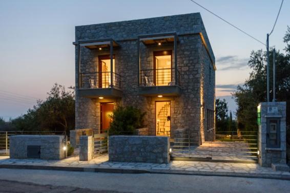 a brick house with a balcony on a street at Thelgi in Kalamata