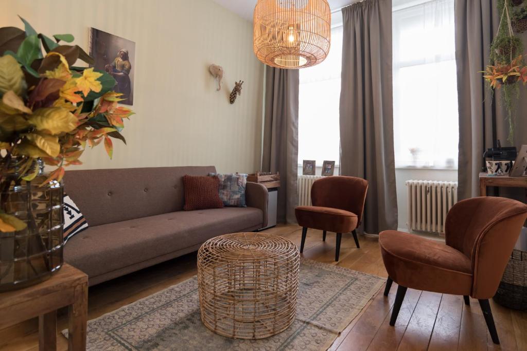 a living room with a couch and a table and chairs at Caesars Studio in Amsterdam