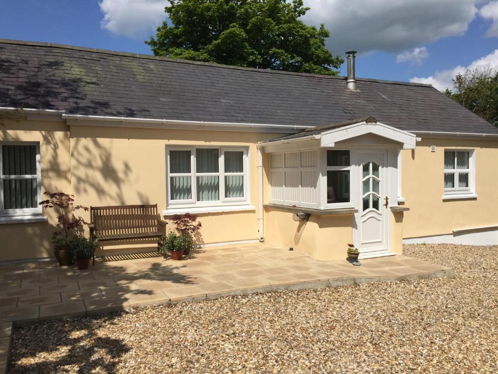 a yellow house with a bench in front of it at Yr Hafan in Trelech