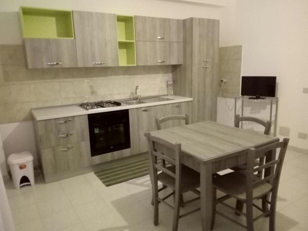 a kitchen with a table and a sink and a stove at Halicia Vacanze in Salemi