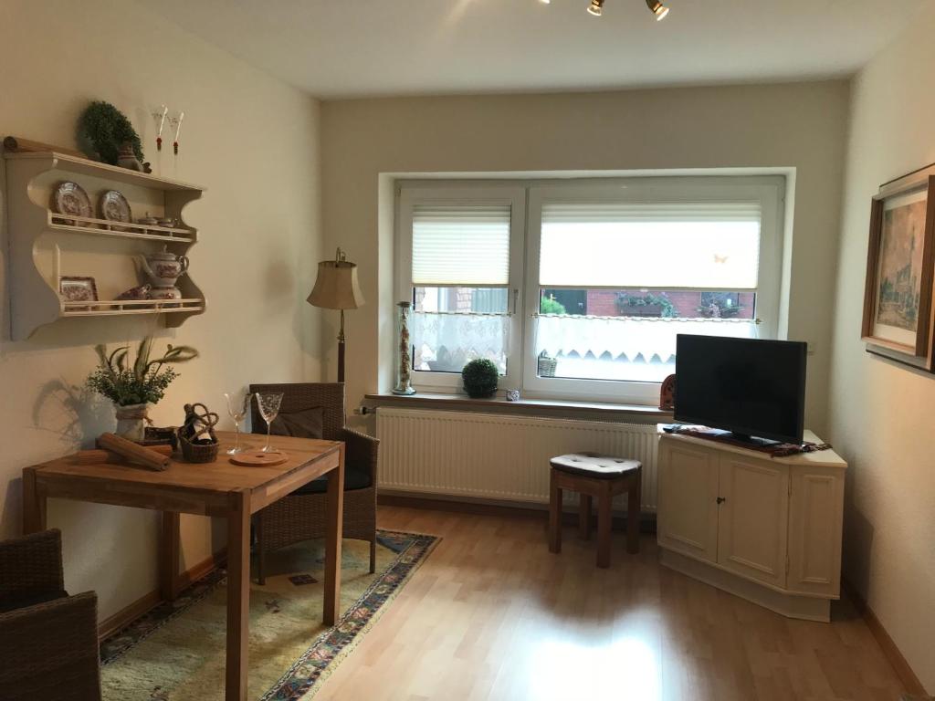 a living room with a television and a table and a window at Ferienwohnung Hage in Hage