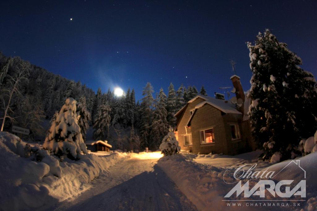 una cabaña en la nieve por la noche en Chata Marga, en Liptovský Mikuláš