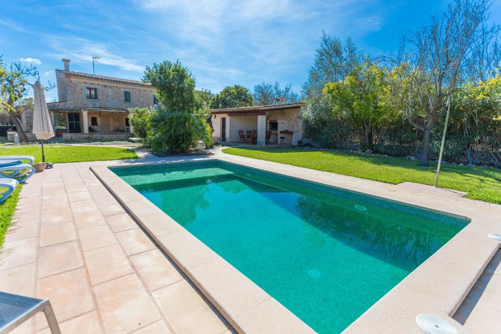 una piscina en un patio con una casa en Pou Vell en Búger