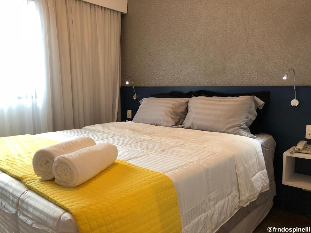 a bedroom with a large bed with towels on it at Apartamento confortável - Itaim Bibi in Sao Paulo