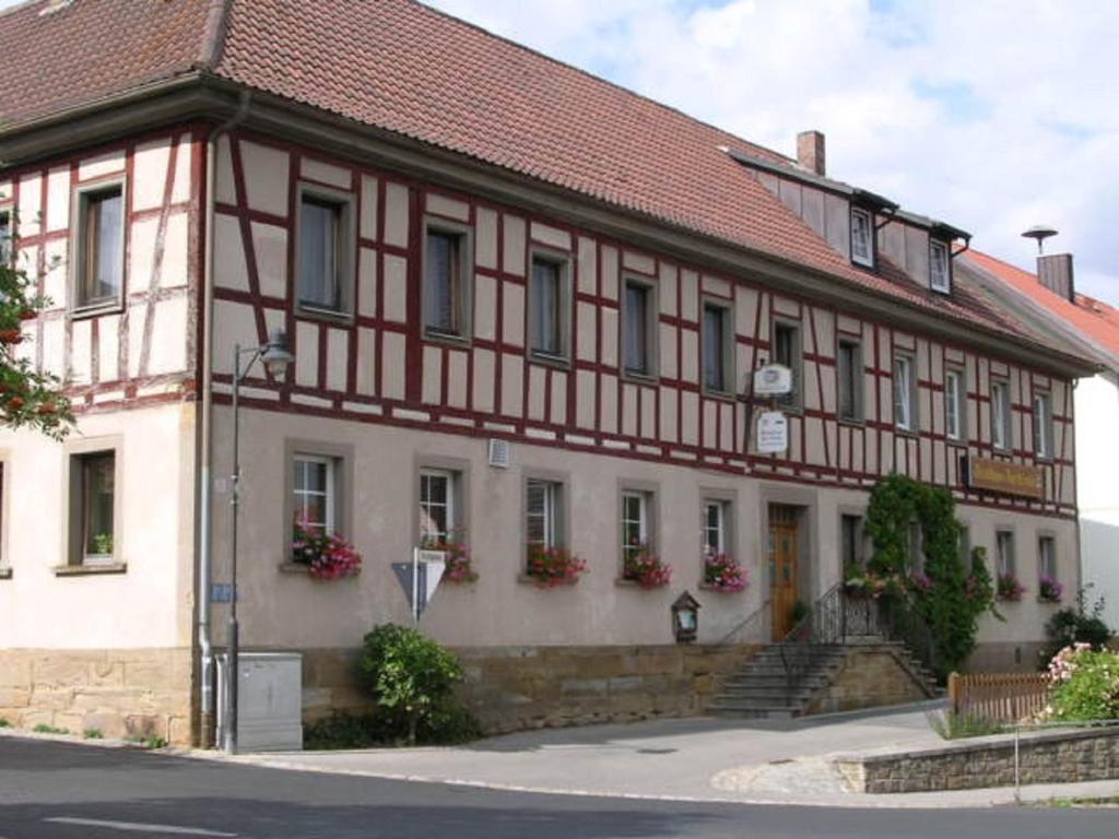 a building with a red and white at Landgasthof "Zur Linde" in Irmelshausen
