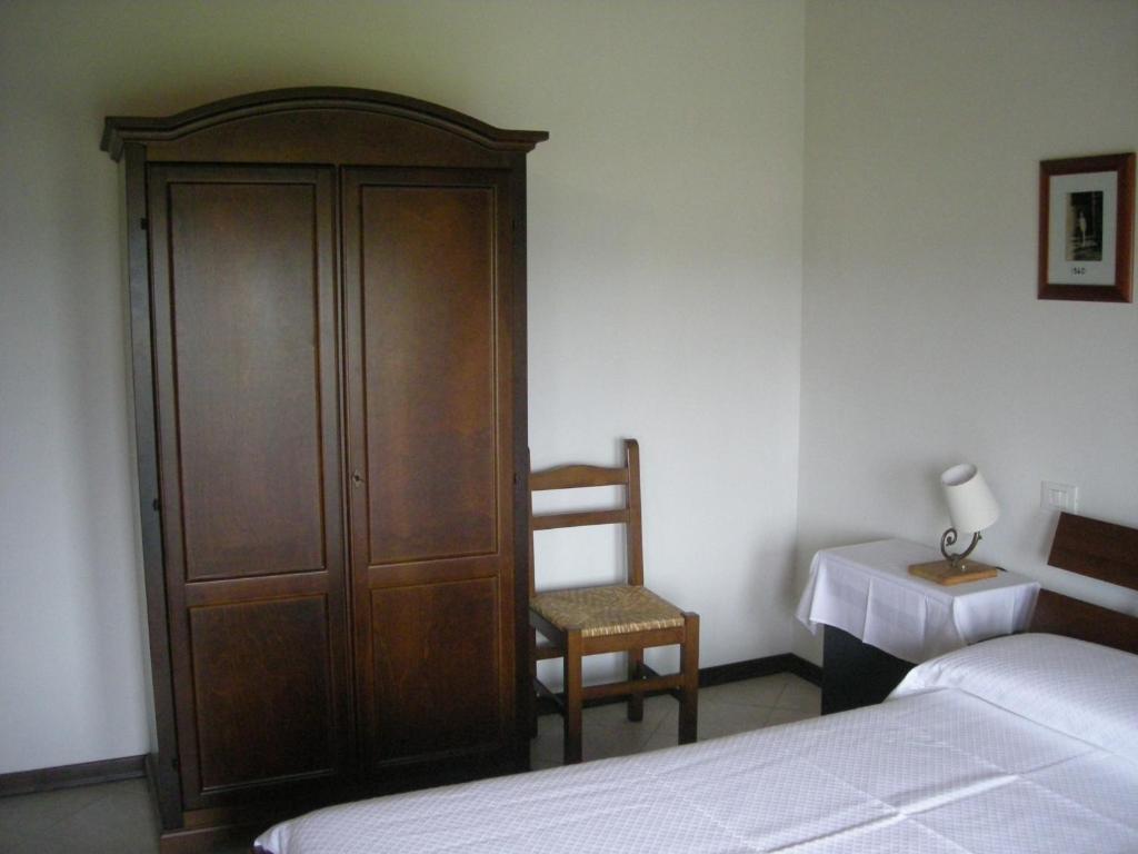 - une chambre avec un lit, une armoire en bois et une chaise dans l'établissement Temporin Ospitalità, à Monselice