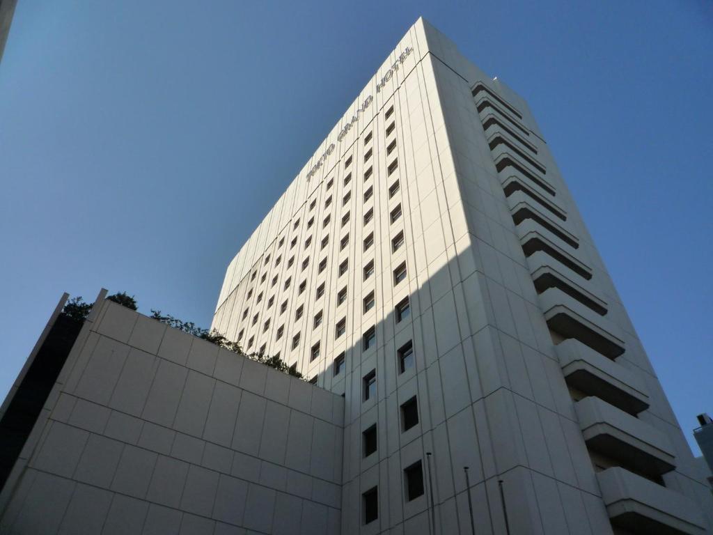 un edificio blanco alto con un cielo azul en el fondo en Tokyo Grand Hotel, en Tokio