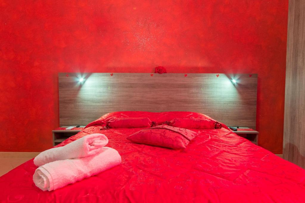 アッリステにあるB&B Rosso Salentoの赤いベッド(ピンクの枕2つ付)