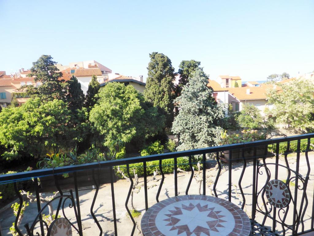 un balcon avec un banc, des arbres et des bâtiments dans l'établissement 4VSE-VER34 Appartement proche plage avec parking, à Collioure