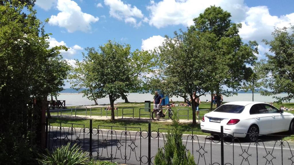 a white car parked in front of a park at Fenyves Beach House in Balatonfenyves