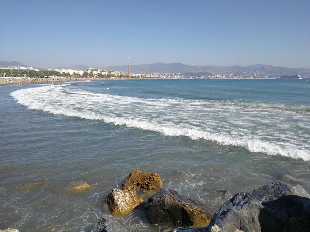 a beach with some rocks in the water at Huelintown in Málaga