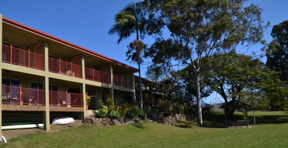 a building with a palm tree in front of it at Tweed River Motel in Murwillumbah