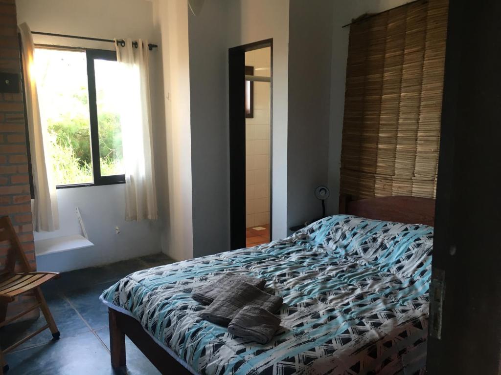 a bedroom with a bed with towels on it at Residencial Casa Santinho in Florianópolis