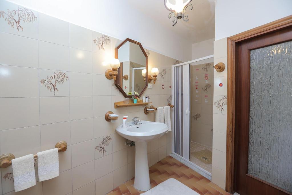 W łazience znajduje się umywalka, lustro i prysznic. w obiekcie Villa Marietta w mieście Minori