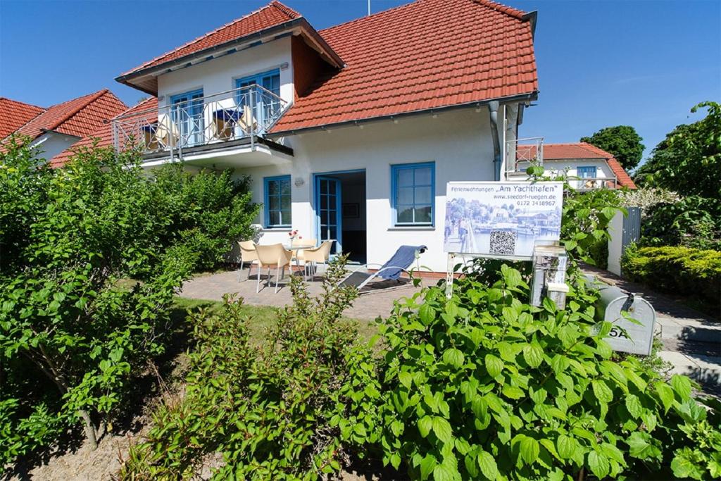 una casa blanca con un cartel delante en "Am Yachthafen" en Seedorf