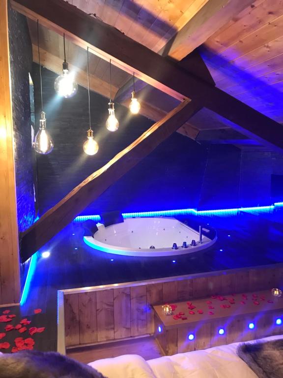 een bad in een kamer met blauwe verlichting bij Le Chalet Loft and Spa in Villeurbanne