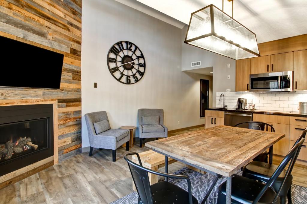 a dining room with a table and chairs and a fireplace at Canalta Lodge in Banff