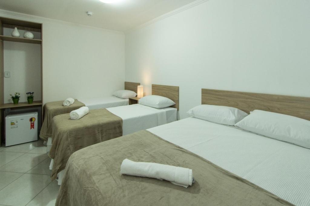 um quarto de hotel com duas camas com toalhas em Hotel Sabor e Fé em Aparecida