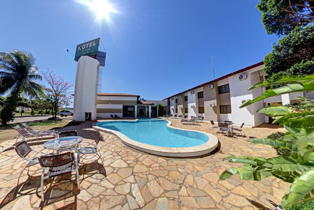 a hotel with a swimming pool in front of a building at Hotel Solar Rio de Pedras in Luís Eduardo Magalhães