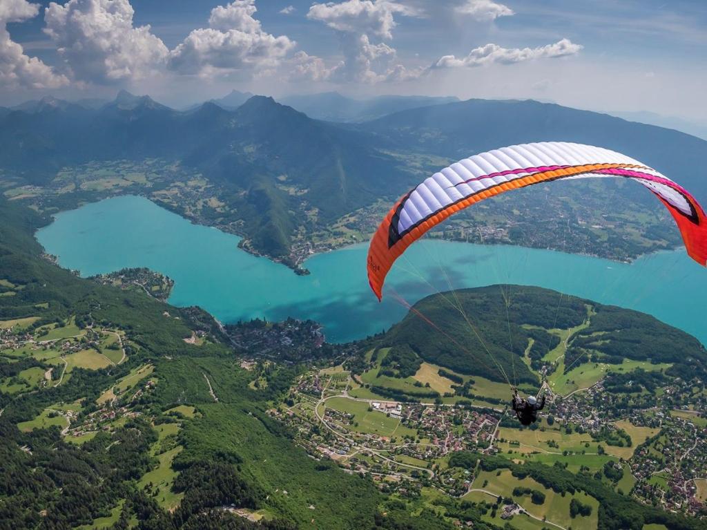 um parapente voando no ar sobre um lago em Maison Cosy Lac d'Annecy em Talloires