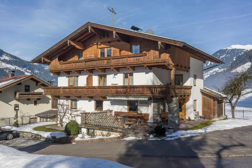 a large wooden house with a balcony in the mountains at Haus Taxacher in Rohrberg