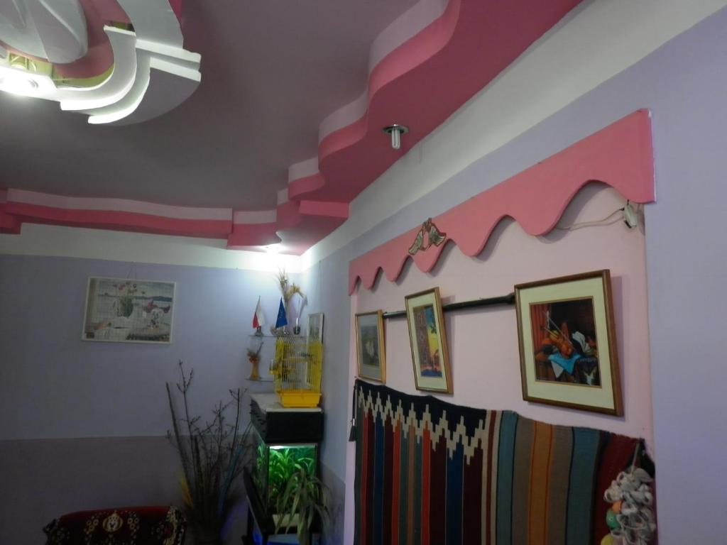 a living room with a pink and white ceiling at Guest House Dompolski in Gyumri