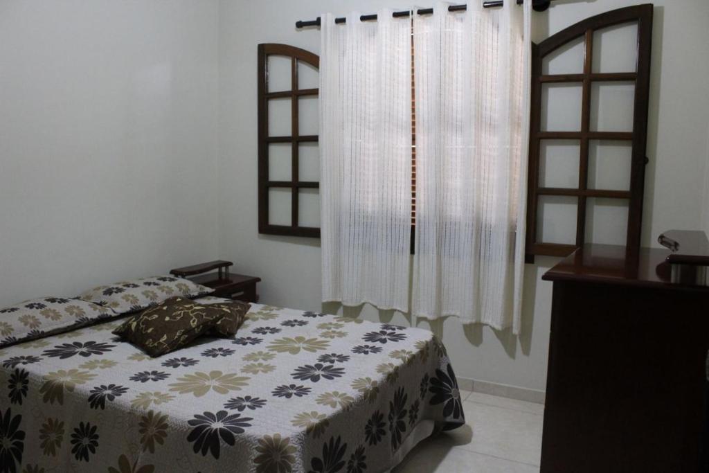 a bedroom with a bed and a window at Sobrado em Arraial do Cabo in Arraial do Cabo