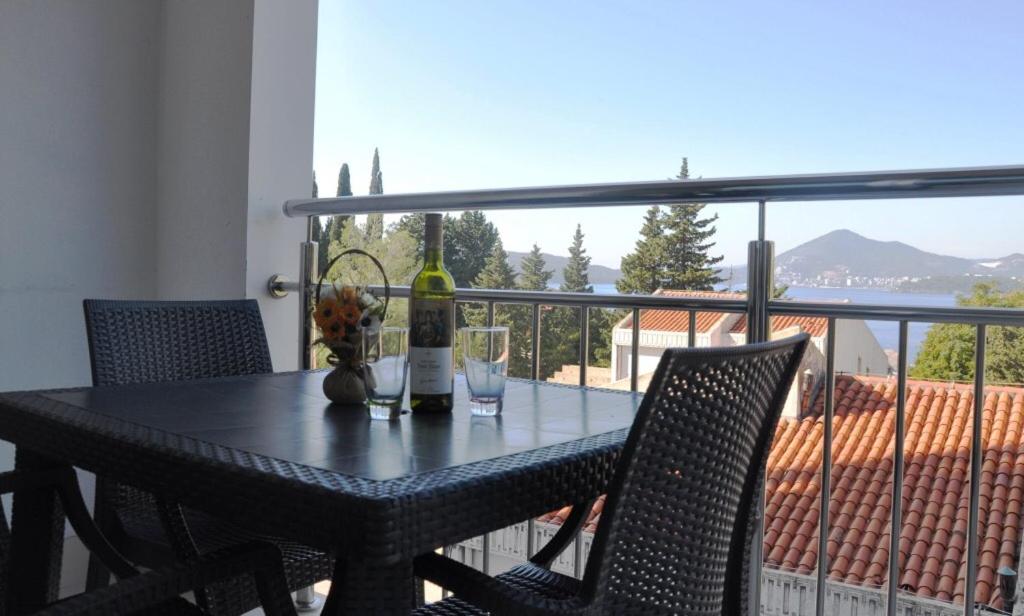 a table with two bottles and two glasses on a balcony at Lux Apartment Przno in Sveti Stefan