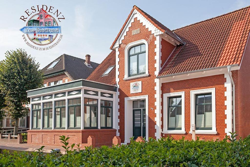 a large brick house with a sign on the side of it at Residenz zum Südstrand/Levke in Borkum