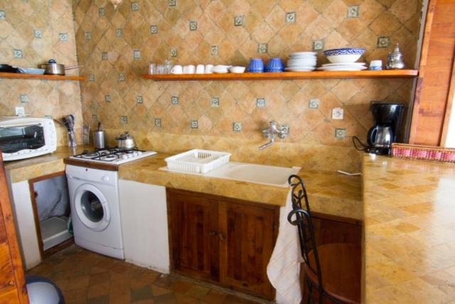 een keuken met een wastafel en een wasmachine bij Appartement Taghazout in Taghazout