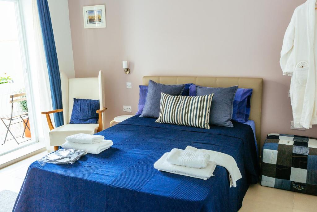 Un dormitorio con una cama azul con toallas. en Ghand in-Nanna B&B en Mellieħa