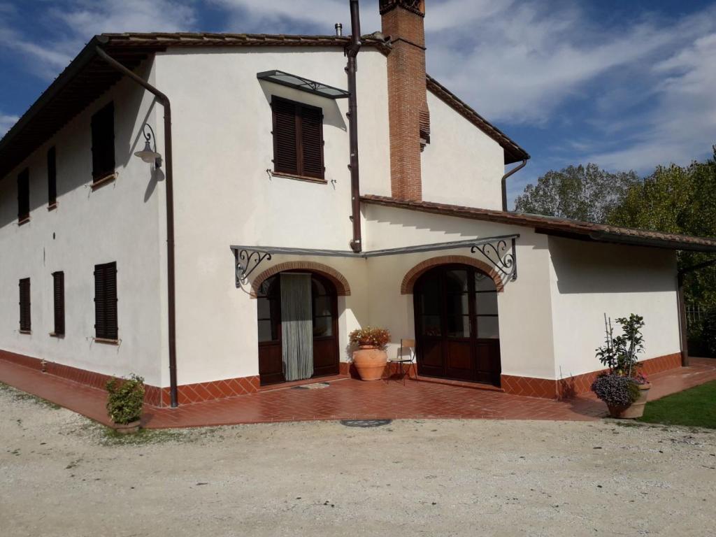 a large white building with a courtyard in front of it at Camere Montalbano in San Miniato