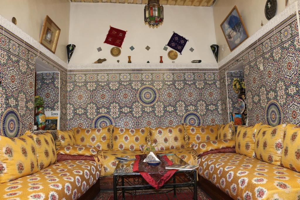 een woonkamer met een bank en patronen op de muren bij Dar Najia in Fès