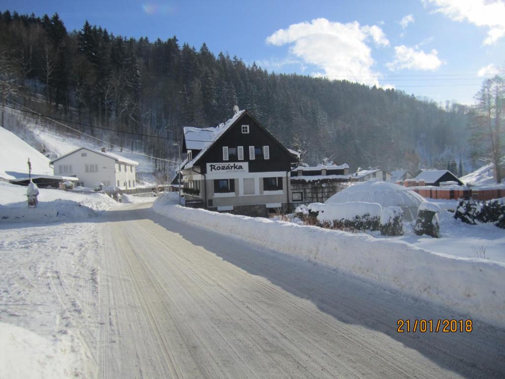 una carretera cubierta de nieve frente a un edificio en Chata Rozárka, en Dolni Dvur