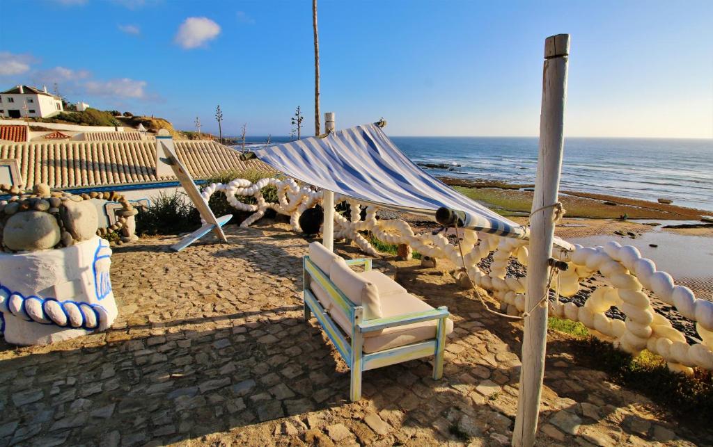 a chair and a hammock on the beach at Villa Ana Margarida Beach in Ericeira