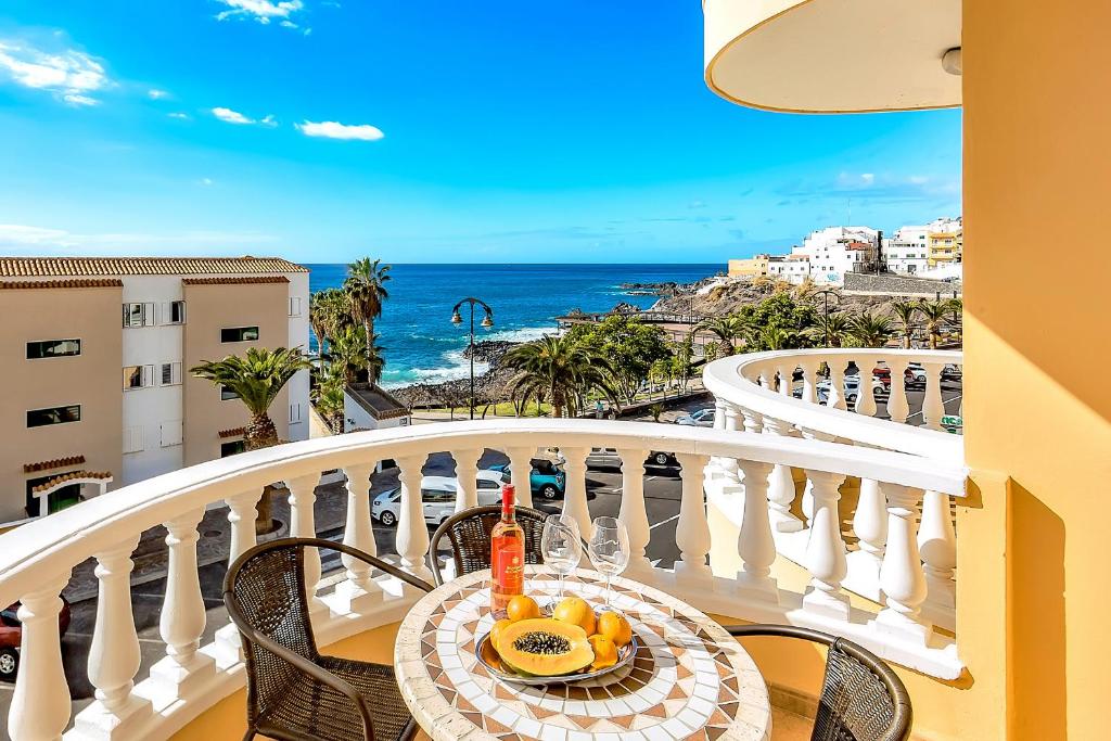 a table on a balcony with a view of the ocean at Ocean Pearl Apartment in Puerto de Santiago