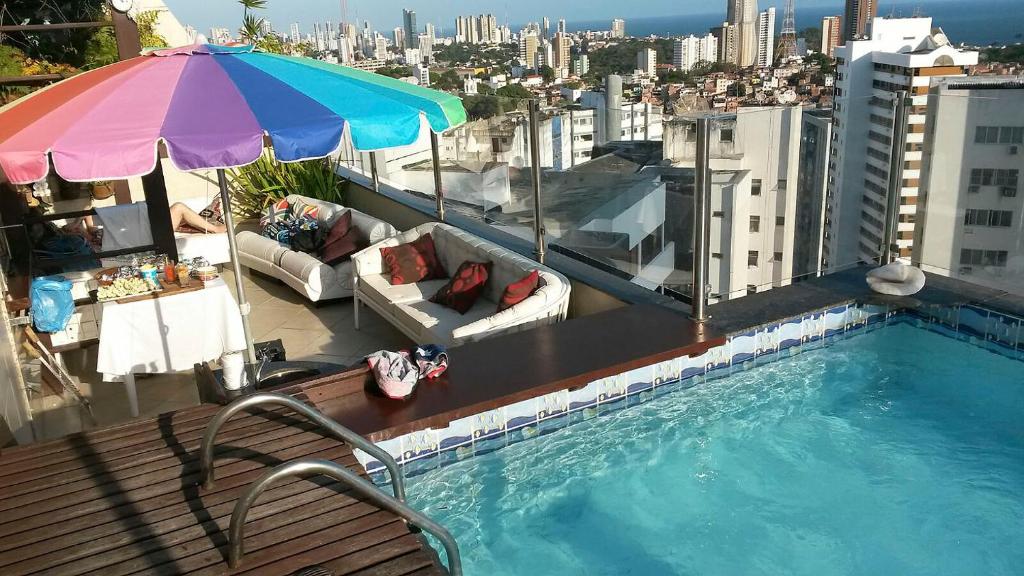 una piscina en la parte superior de un edificio con sombrilla en SSA001 - Cobertura de luxo para 2 pessoas em Salvador, en Salvador