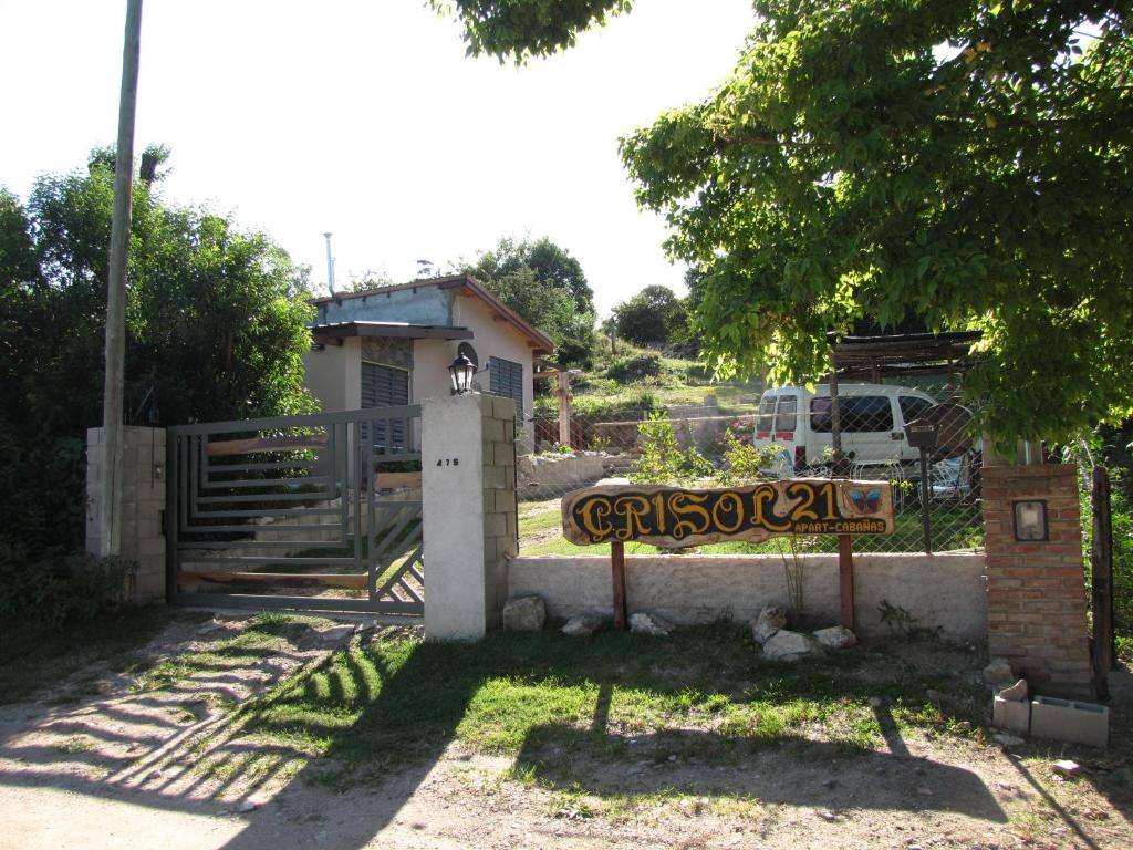 un portail avec un panneau devant une maison dans l'établissement Crisol 21, à Huerta Grande