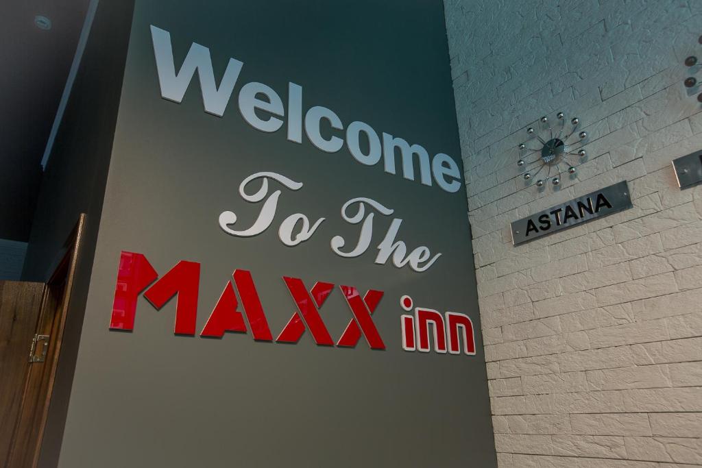 una bienvenida a la señal de máxima en una pared en MAXX inn en Astaná